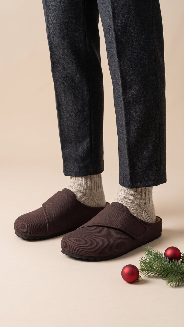 Brown Relief Clogs with oatmeal wool socks on warm oatmeal paper with a fir sprig and red baubles